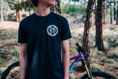 Front of shirt, Men's Trailmap shirt with Bend mountain bike chainring logo.  Men's small, black and orange.